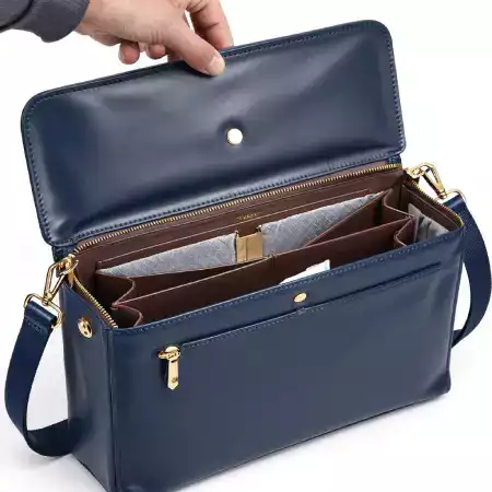 Man with a stylish leather bag looking at a city skyline, representing urban trends