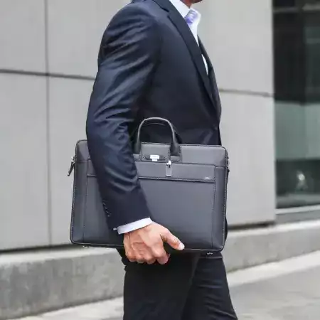 Close-up of a ManBagCo leather wallet and passport on a wooden table, symbolizing travel style