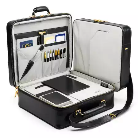 Close-up of a custom-engraved brass zipper pull on a leather bag