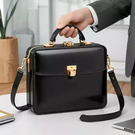 Man in a sharp suit carrying a leather briefcase, walking through a city